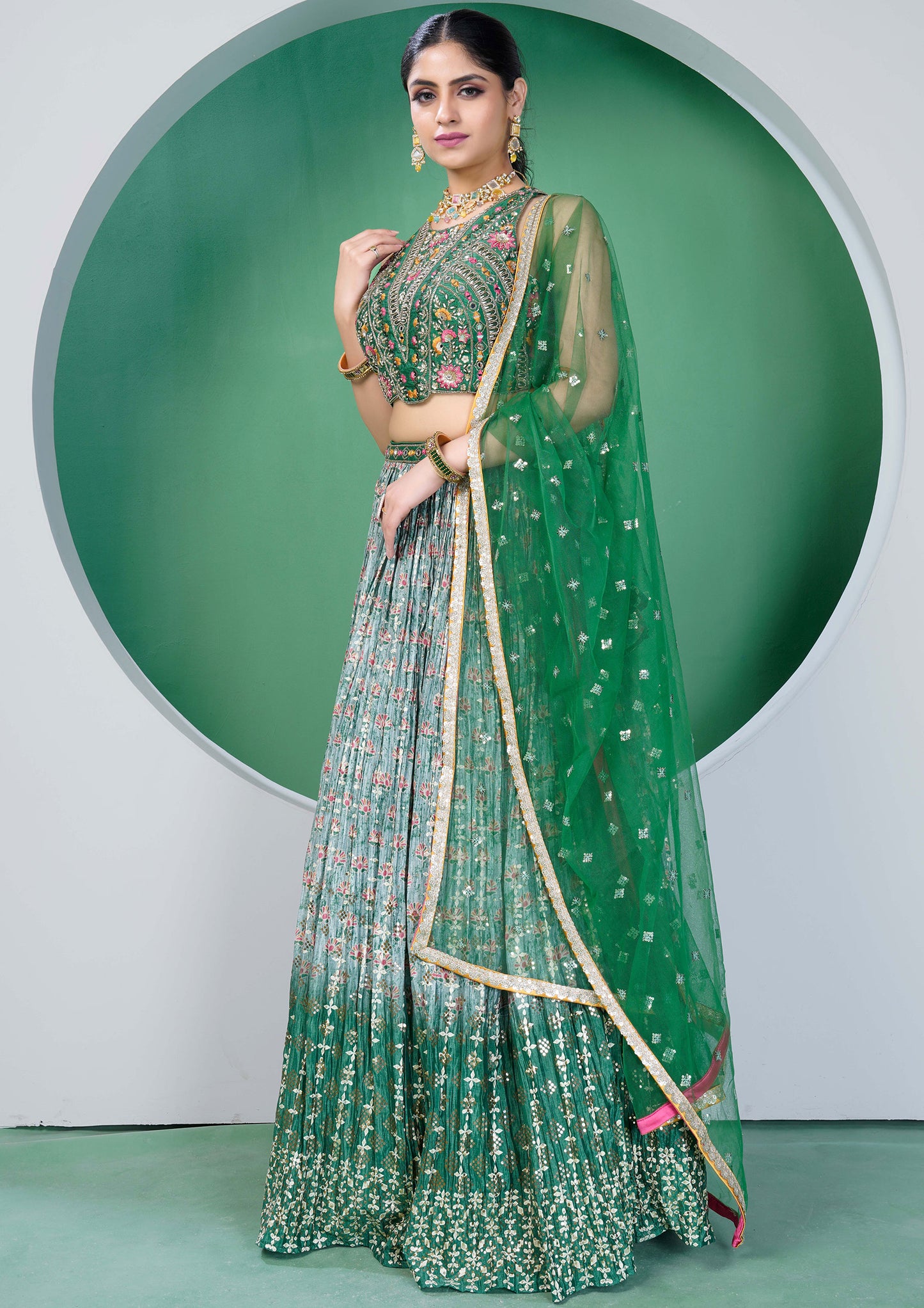A beautiful green and gold embroidered lehenga choli, a traditional Indian outfit for women.