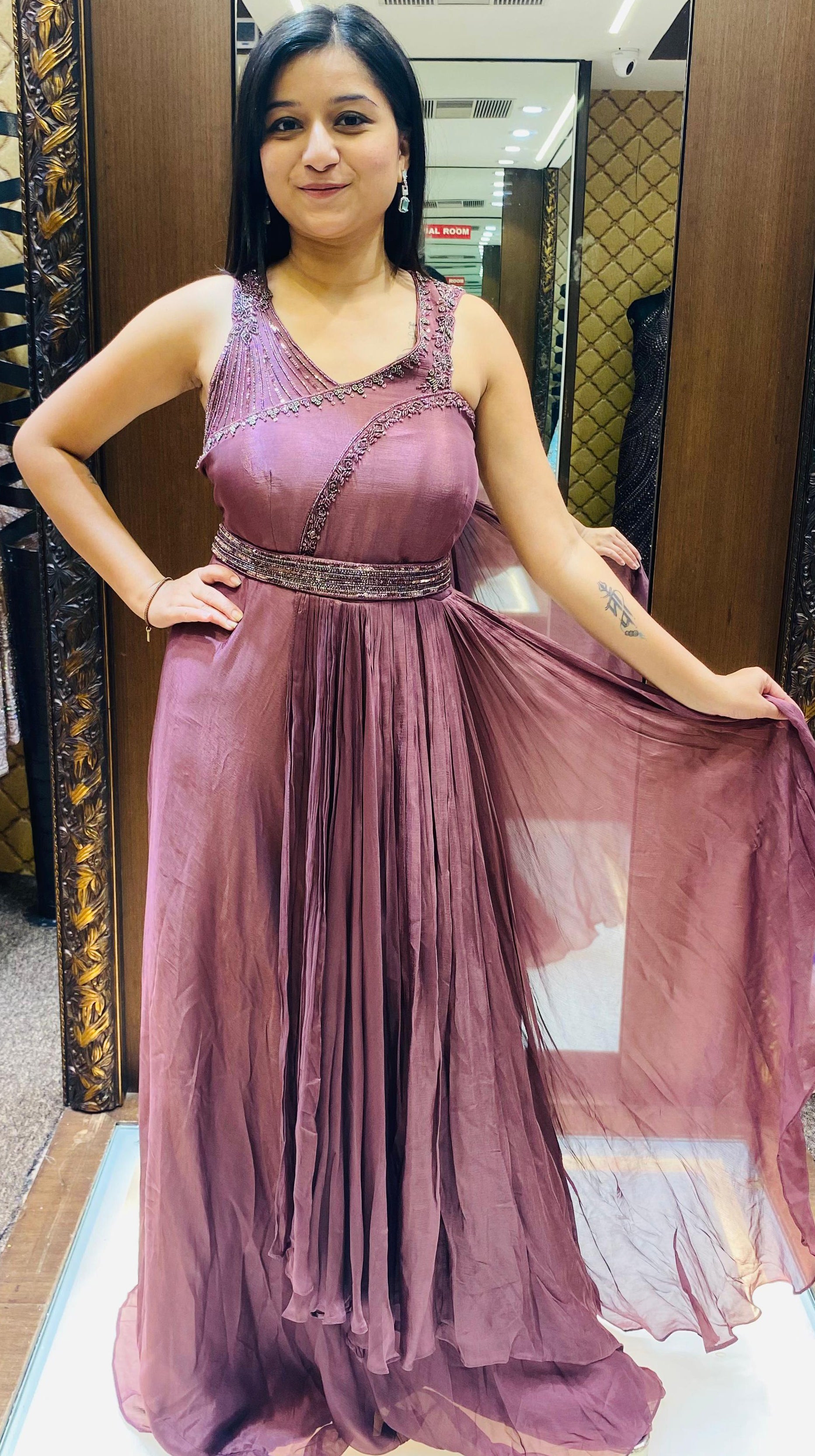 A woman in a flowing purple gown strikes a pose for the camera, showcasing her elegance and poise