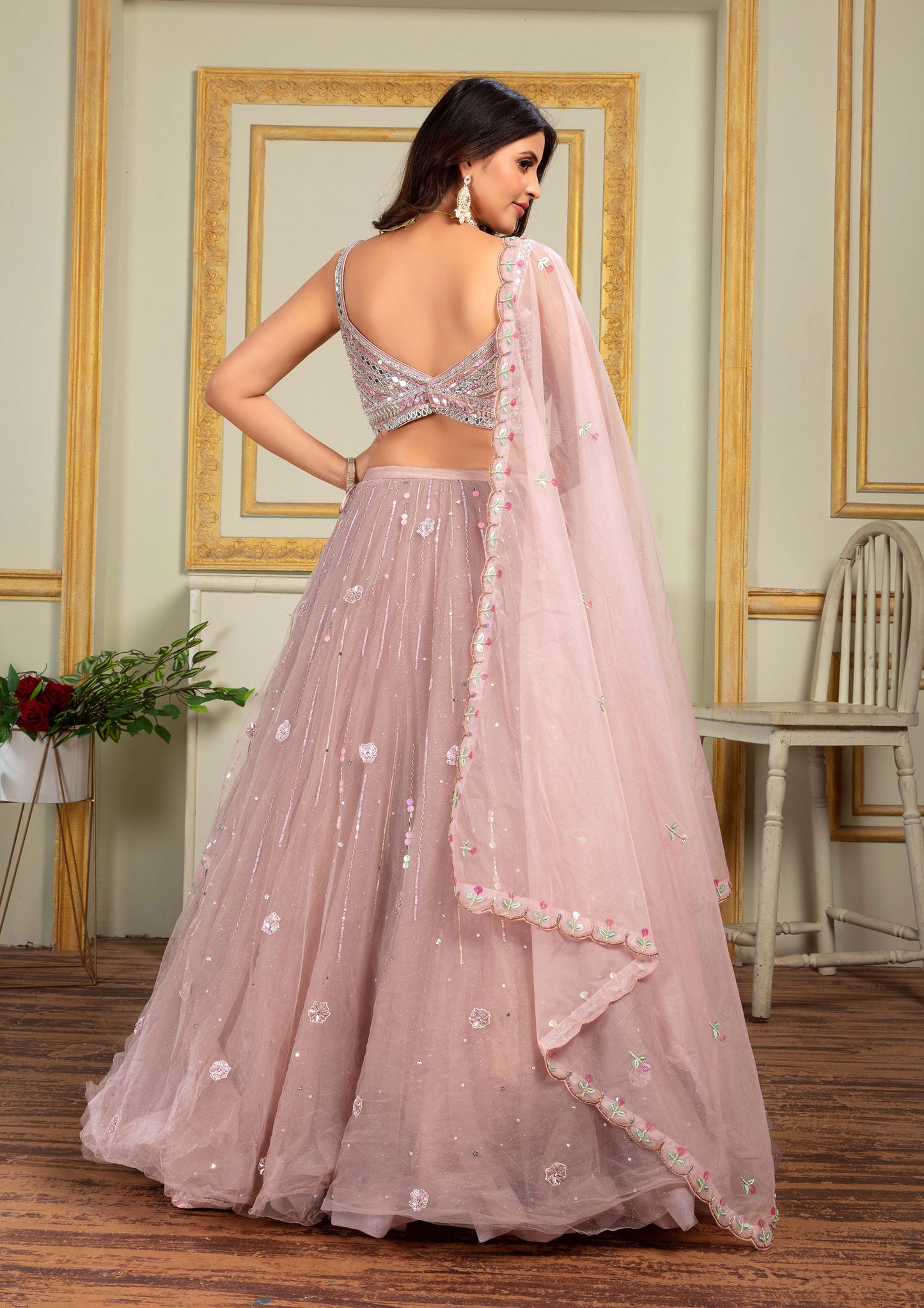 Pink lehenga with floral hand work and net fabric, perfect for a special occasion.