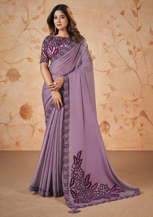 A purple embroidered saree with matching embroidered blouse, showcasing intricate designs and vibrant colors.