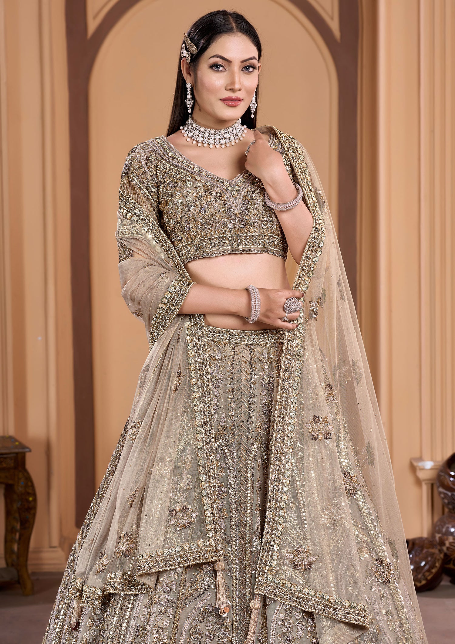 A stunning beige lehenga adorned with intricate embroidery and delicate net work.